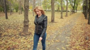 Sonbahar Park güzel ve genç birbayan. deri ceketli sarışın