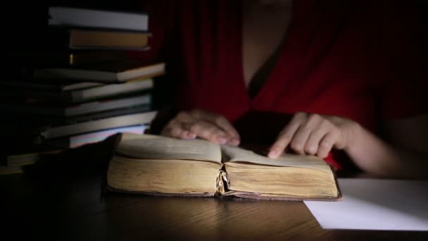 Slimme man laat in de nacht studeren, hij zit aan Bureau- en leesboek — Stockvideo