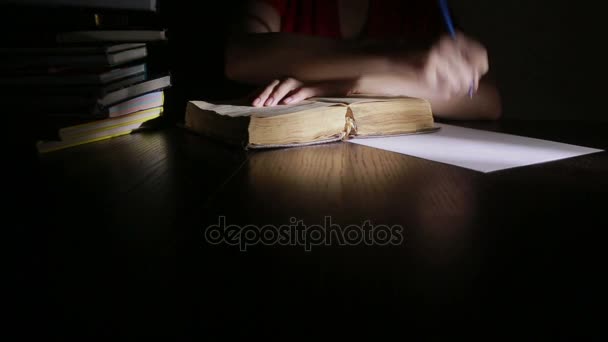 Slimme man laat in de nacht studeren, hij zit aan Bureau- en leesboek — Stockvideo