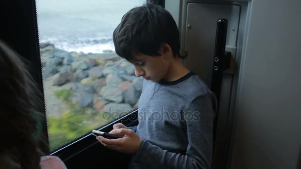 Familia viajando en un tren y mira a través de la ventana al mar — Vídeo de stock
