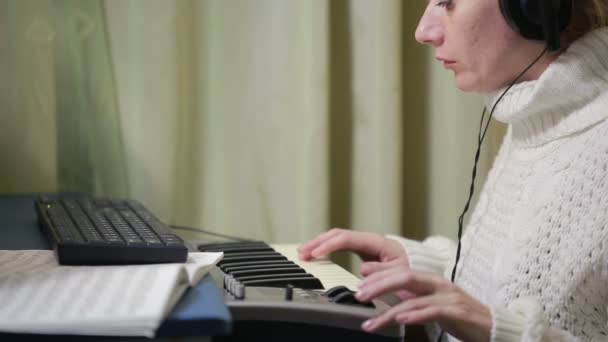 Mujer escribe música en la computadora. teclado midi piano digital — Vídeos de Stock