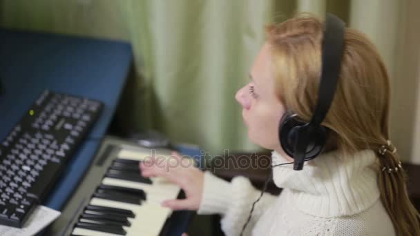Frau schreibt Musik am Computer. digitale Klaviertastatur midi — Stockvideo