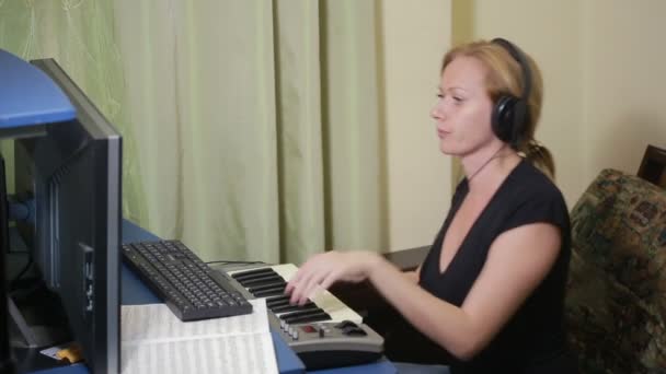 Kobieta pisze muzykę na komputerze. Klawiatura Digital piano midi — Wideo stockowe