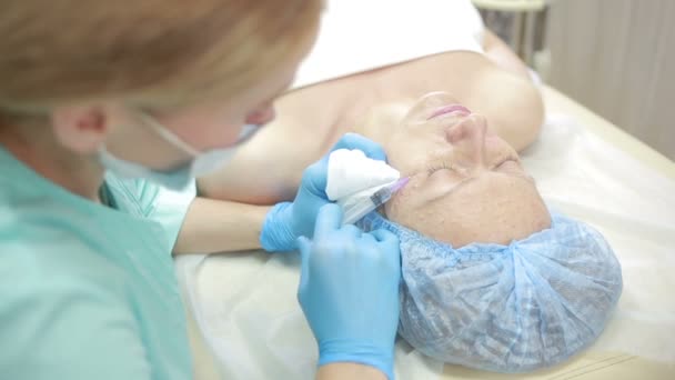 Cosmetische behandeling met een injectie in een kliniek. verrijking van de huid — Stockvideo