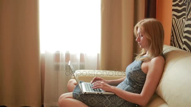 Frau auf Sofa mit Laptop im Wohnzimmer — Stockvideo