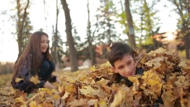 Niños jugando en el parque de otoño — Vídeos de Stock