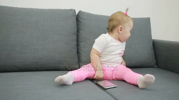 Menina brincando no sofá na sala de estar — Vídeo de Stock