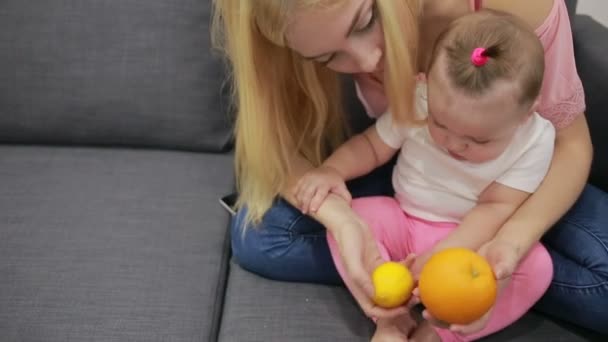 Mor med baby spelar på soffan — Stockvideo