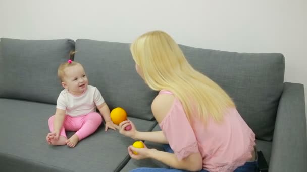 Мама с ребенком играет на диване — стоковое видео
