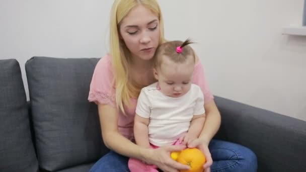 Мама с ребенком играет на диване — стоковое видео