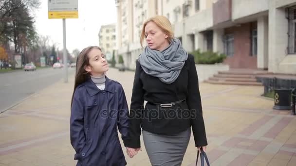 Madre e hija caminando por la calle. otoño frío — Vídeos de Stock