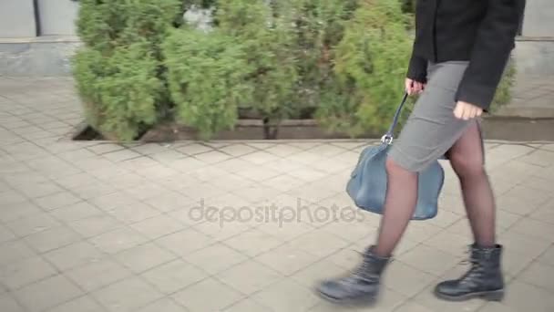 Kvinna i varma kläder och halsduk gångavstånd ner på gatan. — Stockvideo