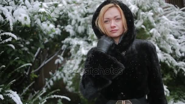 Joven hermosa mujer en abrigo de visón con estilo sobre un fondo de un parque de invierno — Vídeo de stock