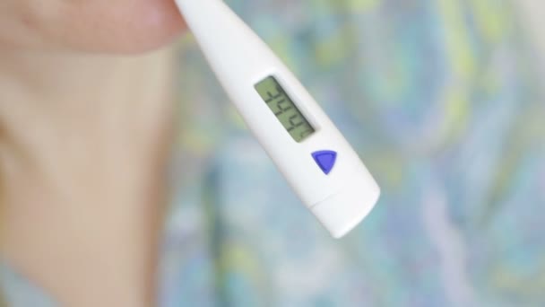 Malade femme avec thermomètre numérique dans la bouche. 36,6 — Video