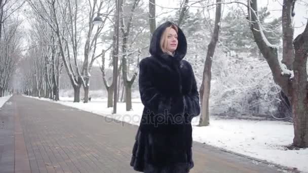 Mladá krásná žena v elegantní kožich na pozadí winter park — Stock video