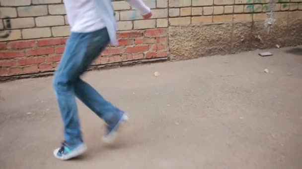 Мальчик-подросток танцует, уличные танцы на фоне кирпичной стены — стоковое видео