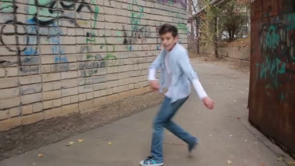 Tiener jongen dansen, straat dansen op de achtergrond van de bakstenen muur — Stockvideo