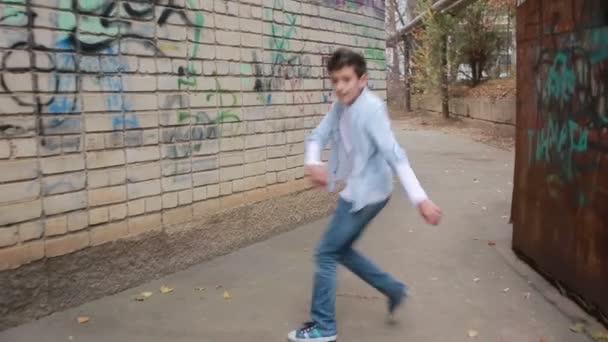 Tiener jongen dansen, straat dansen op de achtergrond van de bakstenen muur — Stockvideo