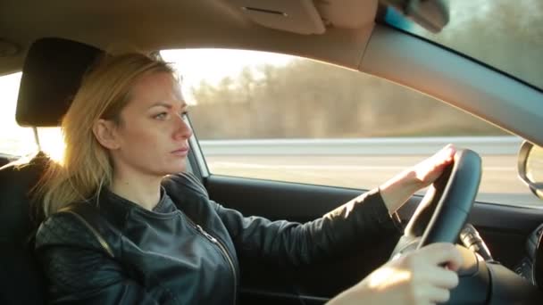 Mujer joven rubia conduciendo un coche — Vídeo de stock