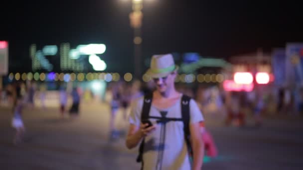 Людина використовує мобільний телефон на вулиці. красивий чоловік в капелюсі зі сморттоном — стокове відео