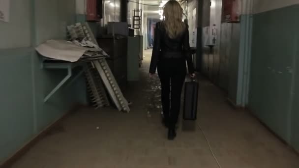 Jonge zakenvrouw loopt weg met koffer. — Stockvideo