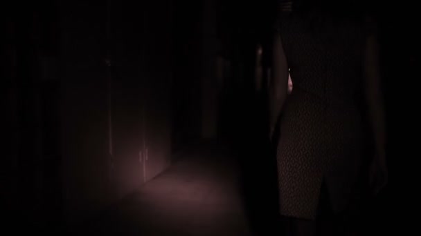 jambes féminines en talons hauts sont sur le couloir sombre 