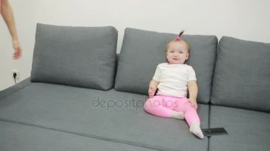 küçük kız oturma odasında kanepede oynamaktan