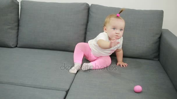 Niña jugando en el sofá en la sala de estar — Vídeos de Stock