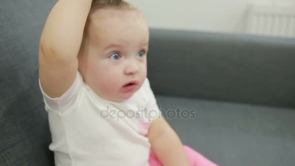Malá dívka hraje na gauči v obývacím pokoji — Stock video