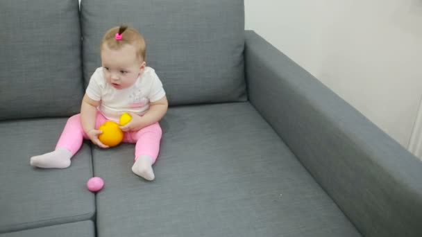 Kleines Mädchen spielt auf der Couch im Wohnzimmer — Stockvideo