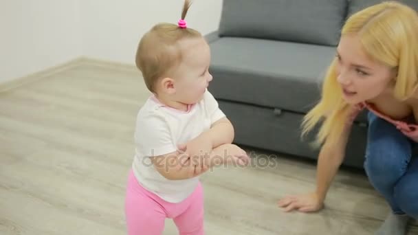 Mãe com seu bebê brincando em um sofá na sala de estar — Vídeo de Stock
