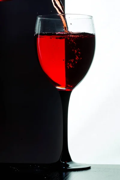 Red wine pouring. white on black background — Stock Photo, Image