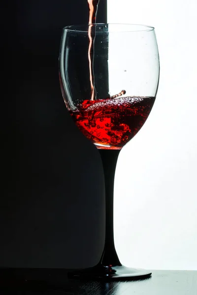 Red wine pouring. white on black background — Stock Photo, Image