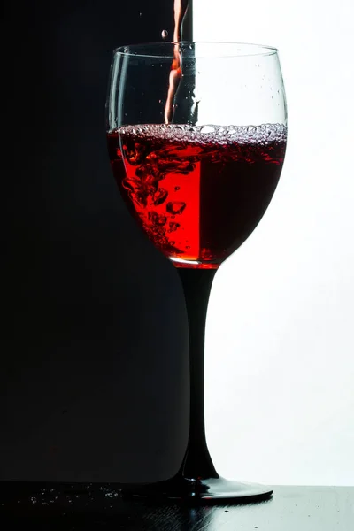 Kırmızı şarap dökülen. siyah arka plan üzerine beyaz — Stok fotoğraf