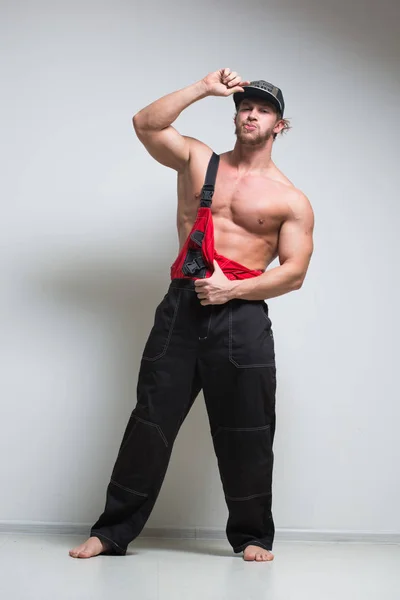 Muscular construction worker in overalls — Stock Photo, Image