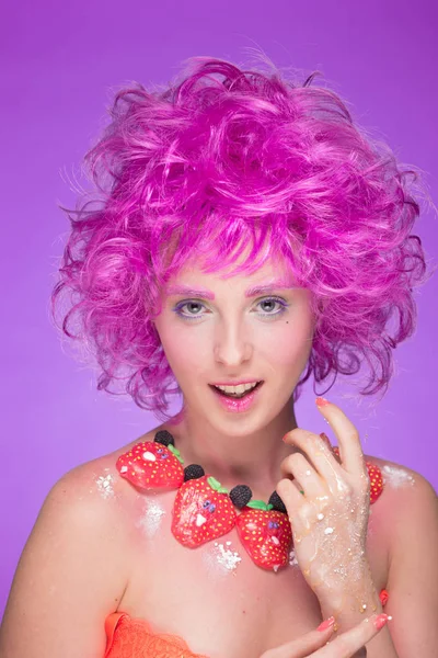 Menina com cabelo rosa. um colar de doces — Fotografia de Stock