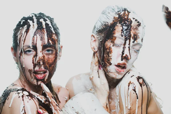 Zwei Mädchen mit weißer und dunkler Schokolade übergossen. Leidenschaftliche Frauen — Stockfoto