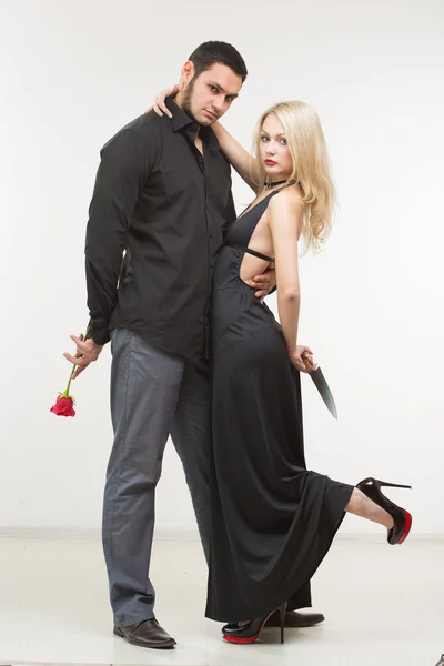 Girl holding knife traitor. man with rose in his hand. — Stock Photo, Image