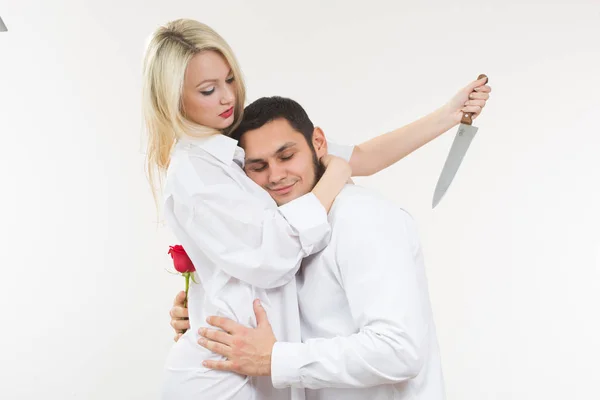 Chica sosteniendo cuchillo traidor. hombre con rosa en la mano . — Foto de Stock