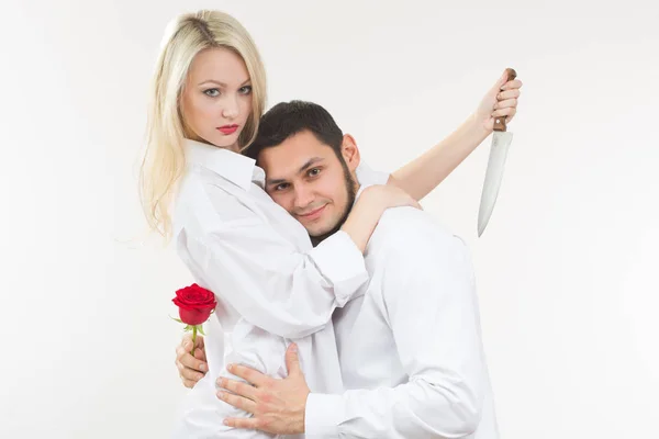 Κοπέλα που κρατά μαχαίρι προδότης. άνθρωπος με τριαντάφυλλο στο χέρι του. — Φωτογραφία Αρχείου
