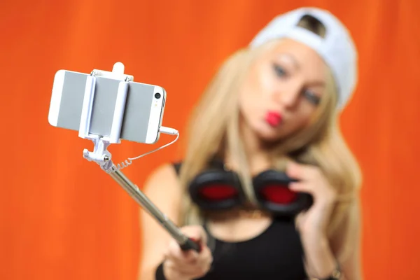 Bella ragazza facendo foto selfe al telefono con bastone — Foto Stock