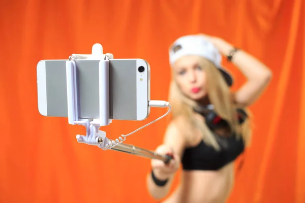 Menina bonita fazendo foto selfe no telefone com vara — Fotografia de Stock