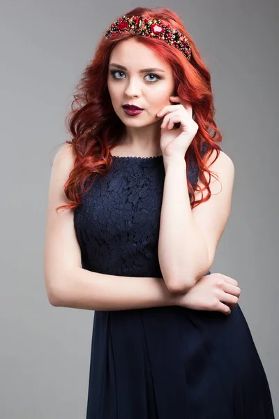 Modelo de pelo rojo posando en vestido de noche y en diadema —  Fotos de Stock