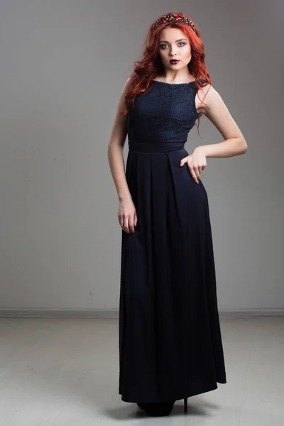 Modelo de pelo rojo posando en vestido de noche y en diadema —  Fotos de Stock