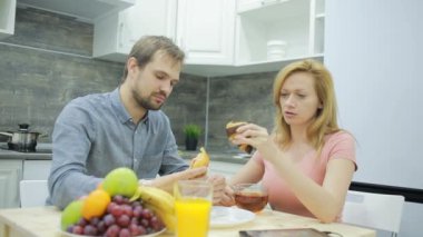 Genç çift mutfakta. çay içme ve meyve yemek