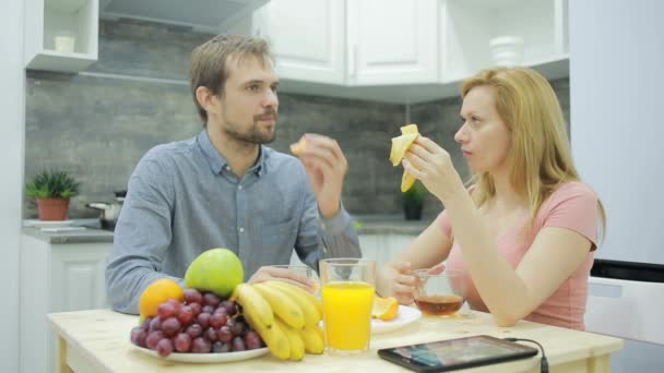 Casal jovem na cozinha. beber chá e comer frutas — Vídeo de Stock