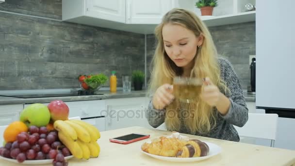 Mooi blond meisje, eten en drinken van gezonde voeding thuis, gezondheidszorg concept — Stockvideo