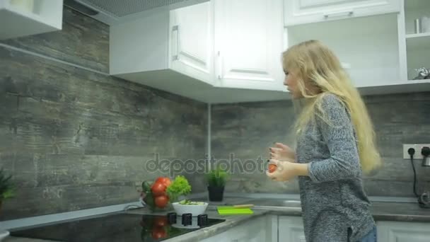 Молодая красивая девушка танцует дома на кухне — стоковое видео