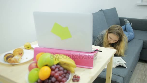 Young girl student doing homework at home on the couch — Stock Video