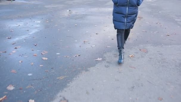 Flicka klädd svart bekämpa stövlar stänk i en vattenpöl efter regn — Stockvideo